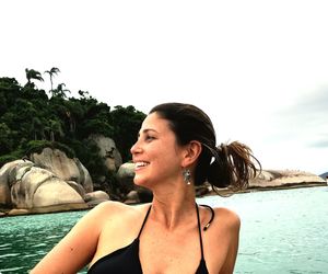 Smiling woman at beach against clear sky