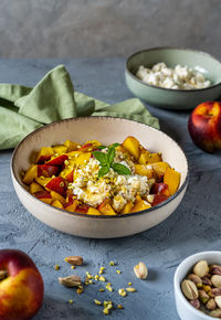 Healthy fruit salad with nectarine, ricotta cream with pistachios and honey