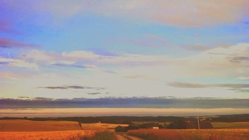 Scenic view of field against cloudy sky