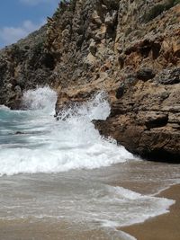 Rock formation in sea against sky