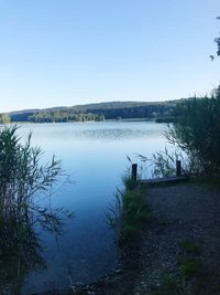 Scenic view of lake against clear blue sky