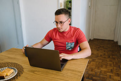 Man using his laptop and drinking coffee.