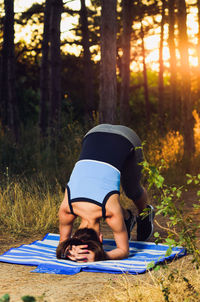 Midsection of woman with arms raised in forest