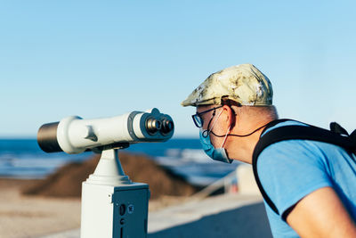 Man holding camera against sky