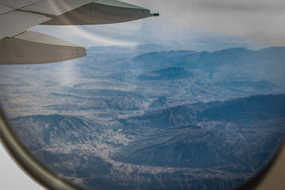 Cropped image of airplane wing over landscape