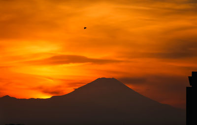 Silhouette of mountain against cloudy sky during sunset