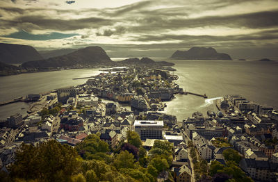 High angle view of townscape by sea against sky