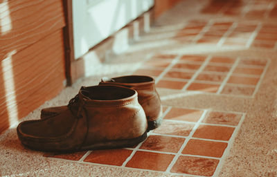 Close-up of shoes on tiled floor