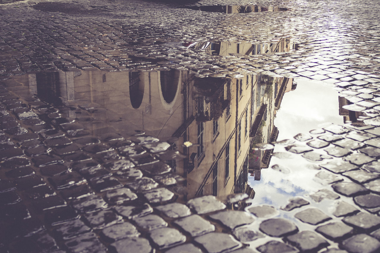 LOW ANGLE VIEW OF PUDDLE ON WALKWAY