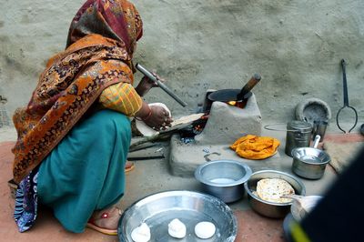 Side view full length of woman preparing roti