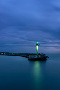 Stone pier in darlowo in the evening. lights on the beach. traffic lights in the port. blue hour. 