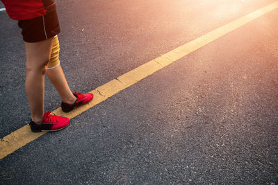 High angle view of athlete standing over road marking over road