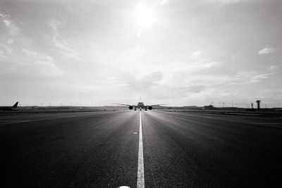 Airplane on runway against sky