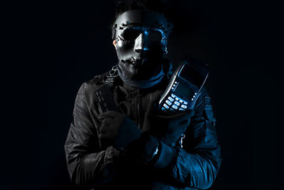 Man using smart phone against black background