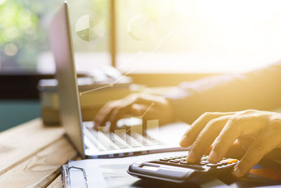 Close-up of person using laptop on table