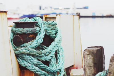 Close-up of rope tied to bollard at pier