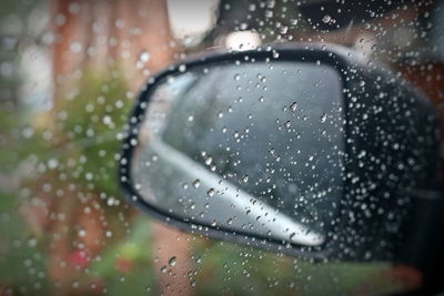 Rain drop on the window and a glass outside the car in the raining day.
