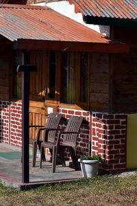 Empty chairs and tables against building