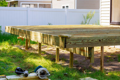 Empty chairs and table in yard against house