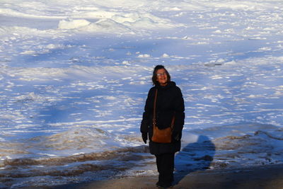 A lady walking by a frozen lake
