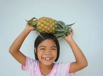 Portrait of smiling girl holding fruit