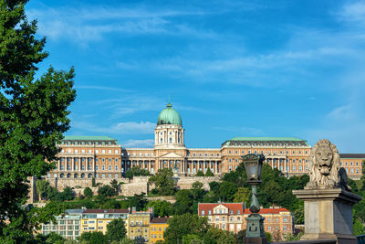 Buildings in city against cloudy sky