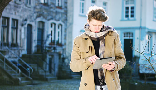 Full length of man using mobile phone in city