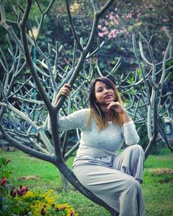 Portrait of young woman sitting on grass