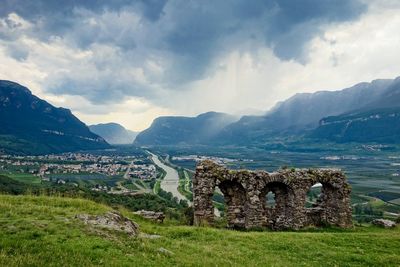 Old ruins on mountain against cloudy sky