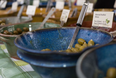 Close-up of olives in containers with labels at market stall