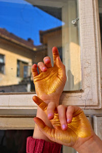 Close-up of woman hand holding ice cream by building