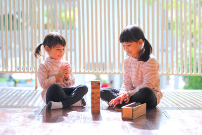 Siblings sitting on floor