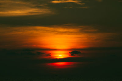 Scenic view of sea against dramatic sky during sunset