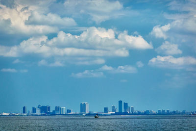 Modern buildings by sea against sky