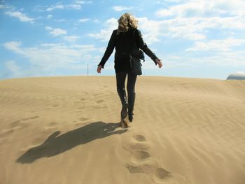 Rear view of woman walking on beach