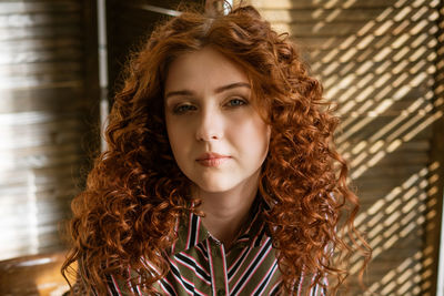 Portrait of a young red-haired woman with sad eyes