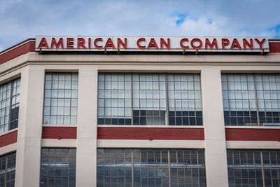 Low angle view of sign on building against sky