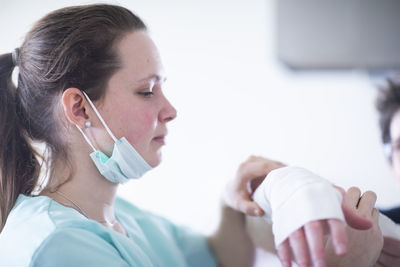 Nurse making a armwraps to a patient female