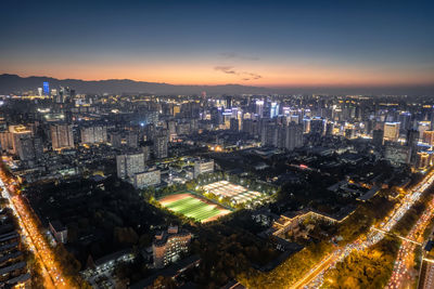 High angle view of illuminated cityscape against sky during sunset