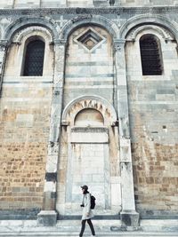 Full length of woman standing outside historic building