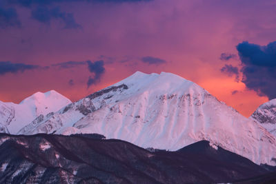 Scenic view of snowcapped mountains against sky during sunset