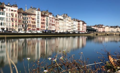 Lake by buildings against sky