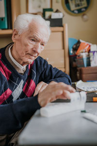Senior man holding medicine at home