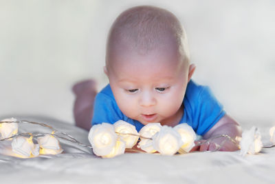 Close-up of cute baby boy with decoration lying on bed