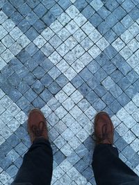 Low section of man standing on cobblestone street