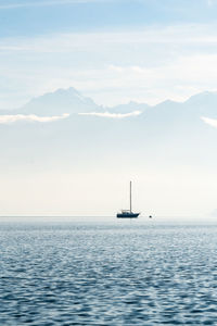 Sailboat sailing on sea against sky