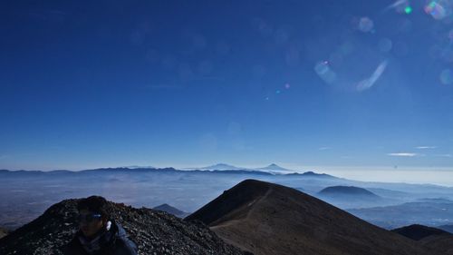 Scenic view of mountain against blue sky