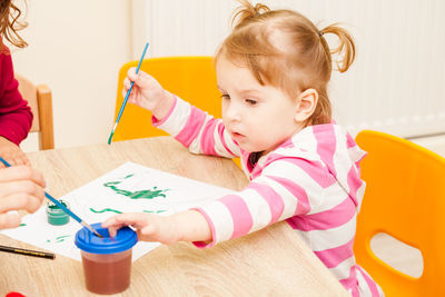 Cute girl sitting on table