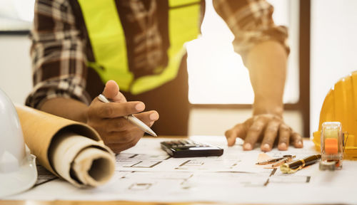 Midsection of man working on table