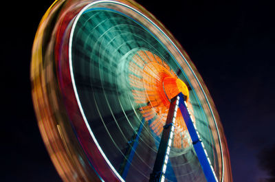 Blurred motion of ferris wheel against sky at night